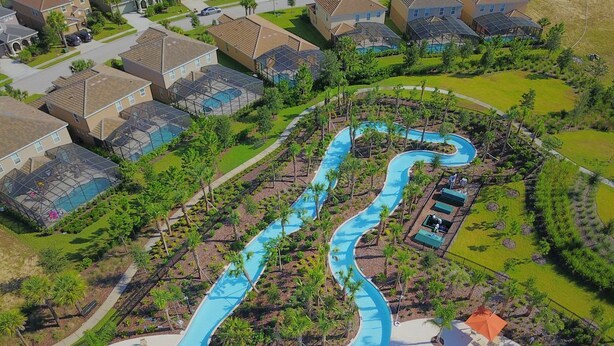 Un quartier résidentiel avec une piscine sinueuse, des maisons et de la verdure.
