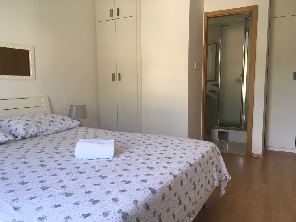 A bedroom with a bed, a wardrobe, and a bathroom door.