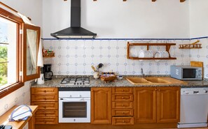 A kitchen with a stove, oven, microwave, and a sink. - Alcoraia 408 traditional finca with private pool, terrace, barbecue and air conditioning (Campos)