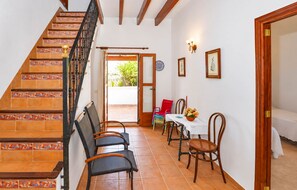 Escadaria com ladrilhos estampados que leva a uma área de refeições com cadeiras e uma mesa.