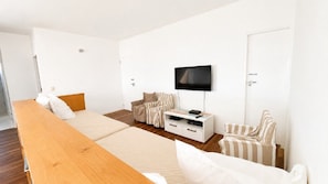A hotel room with a bed, a TV, a desk, and a chair.