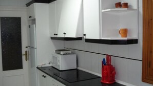 A kitchen with white cabinets, a black countertop, a toaster, and a red utensil holder. - APTO, WIFI in ACANTILADO 'VIEW TO THE SEA'. PARKING (Aguilas)
