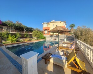 室外游泳池，提供泳池遮陽傘和日光浴躺椅