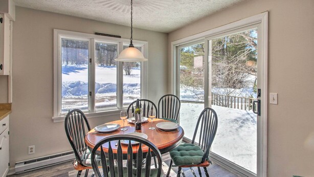 A dining area with a round table, chairs, and a pendant light. - Parsonsfield Vacation Rental Near Skiing & Lakes! (Parsonsfield)