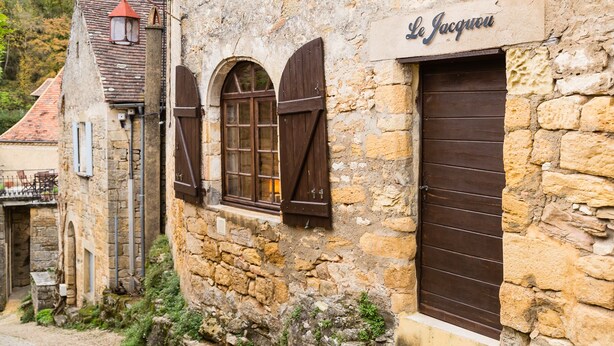 A stone building with a sign reading "Le Jacquou".