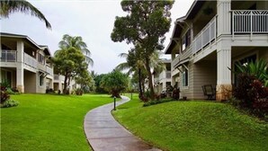 A residential street with houses, a curved sidewalk, and lush green lawns. - Hawaiian Escape with all the Amenities  (Kapolei)