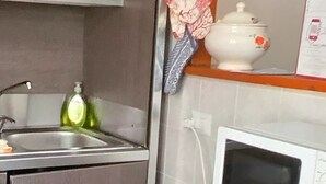 Une cuisine équipée d’un four à micro-ondes, d’un évier et de placards.