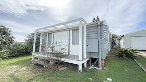 A single-story house with a porch, a garage, and a small garden area. - Jack s Cottage - perfect Wooli escape (Wooli)
