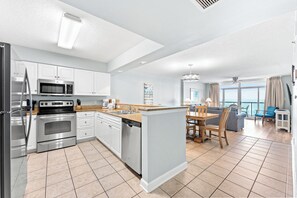 A modern kitchen with stainless steel appliances, a dining area with a view, and a living space with a balcony. - Clean Beachfront 8th Floor. Huge Pool, Lazy River | Bluewater Keyes - 803 (North Myrtle Beach)