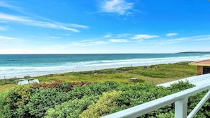 A coastal property with a view of the ocean, a fenced yard, and a balcony with a railing. - On The Beach - located on the sand dunes. (Wooli)