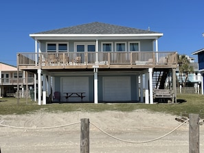 A two-story house with a balcony, a garage, and a picnic table.