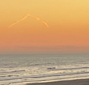 A beach scene with a clear sky and ocean waves.