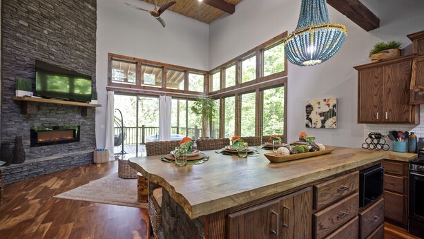 Una cocina amplia con una isla grande, armarios de madera y una chimenea de piedra.