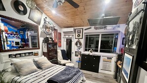 Une chambre à coucher comprenant un lit, un bureau, une chaise, un radiateur et une fenêtre.