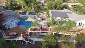 Vue aérienne d’une propriété résidentielle dotée d’une piscine, d’une terrasse et d’un petit quai pour bateaux.
