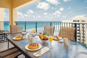 A breakfast table with waffles, fruit, and juice on a balcony overlooking the ocean. - The Royal Sands All Inclusive Resort & Spa (Cancun)