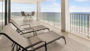 A balcony with seating and a view of the ocean. - Windward Pointe 1401 : Beachfront Corner Condo w/ Wrap-Around Gulf Views (Orange Beach)