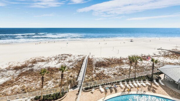 A beach view with a pool, lounge chairs, and a boardwalk. - Windward Pointe 1401 : Beachfront Corner Condo w/ Wrap-Around Gulf Views (Orange Beach)