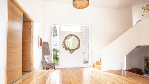 A spacious room with wooden flooring, a large mirror, a zebra-patterned chair, and a staircase leading to another level. - Rathescar Grove (Dunleer)