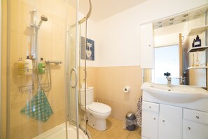 Comfort vierpersoonskamer | Badkamer | Een douche, gratis toiletartikelen, een haardroger, handdoeken