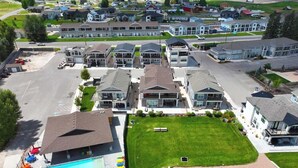 Um bairro residencial com casas modernas, piscina e gramado bem cuidado.