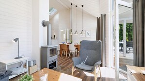 Una sala de estar moderna con chimenea, comedor y vistas al exterior.
