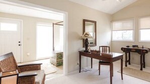 A spacious living room with a high ceiling, a dining table, a sofa, and a fireplace. - Loft In Kailua - Spacious with Parking, Internet and minutes to Kailua Beach! (Kailua)