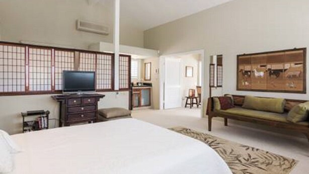 A hotel room with a bed, a TV, a dresser, a sofa, and a traditional Japanese shoji screen. - Loft In Kailua - Spacious with Parking, Internet and minutes to Kailua Beach! (Kailua)