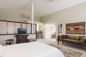 Een hotelkamer met een bed, een televisie, een dressoir, een bank en een traditioneel Japans shoji-scherm.