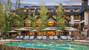 A hotel with a swimming pool, outdoor seating, and a multi-story building with balconies. - Inviting, cabin like condo, close to Gore Creek w/ access to all Grand Hyatt Amenities (Vail)