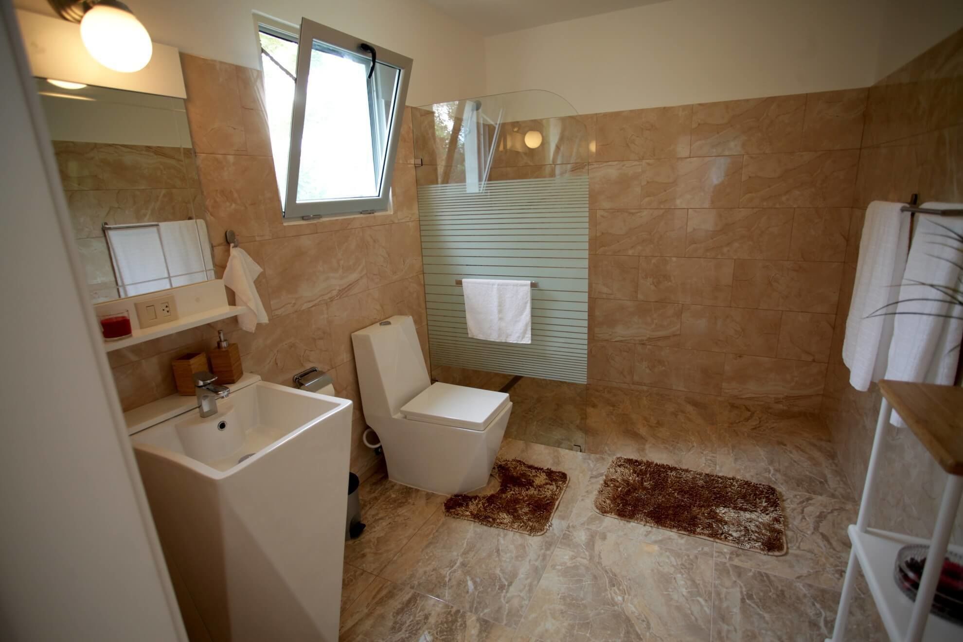 Un baño con inodoro, lavabo y ventana.