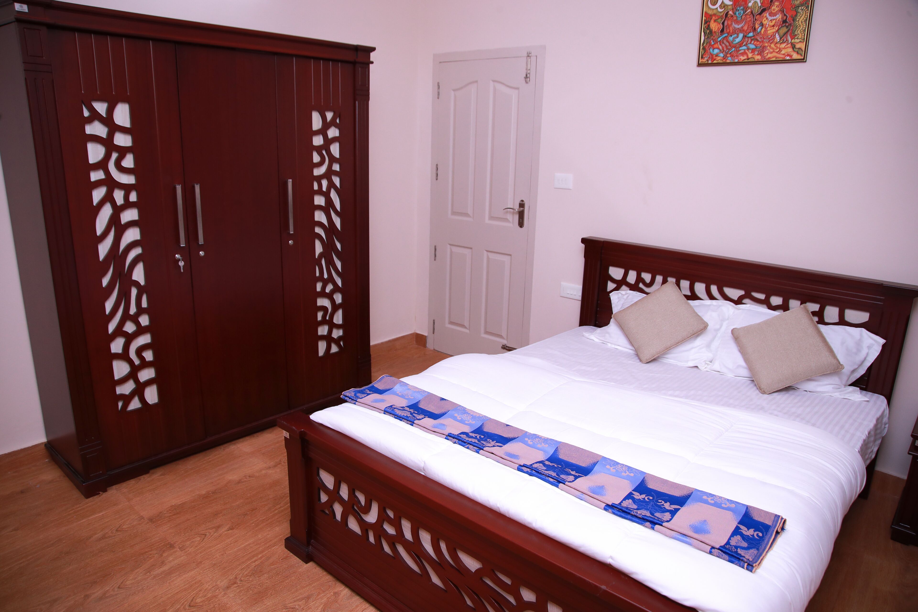 A bedroom with a wooden bed, a wardrobe, and a door.