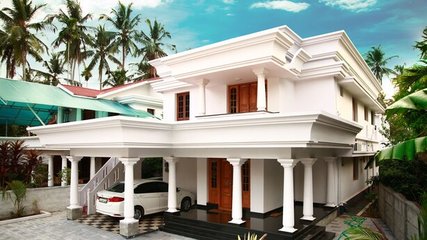 A two-story white building with a covered porch, columns, and a staircase leading to the entrance. - Dvārakā: Luxury Villas of Guruvayur (Guruvayur)