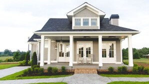 A two-story house with a covered porch, a front door, and a small front yard. - Luxury Cottage in the Heart of North Georgia (Dahlonega)