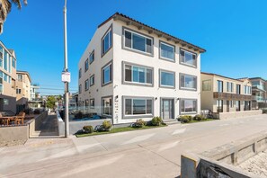 A multi-story building with a balcony, a sign indicating regulations, and a clear view of the street. - Right on the Famous Mission Beach Boardwalk - Sleeps up to 18 on Ground Floor - Best location in Mission Beach (San Diego)