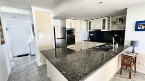 A modern kitchen with granite countertops, stainless steel appliances, and a built-in island. - Sand N Salt - spectacular views (Minnie Water)