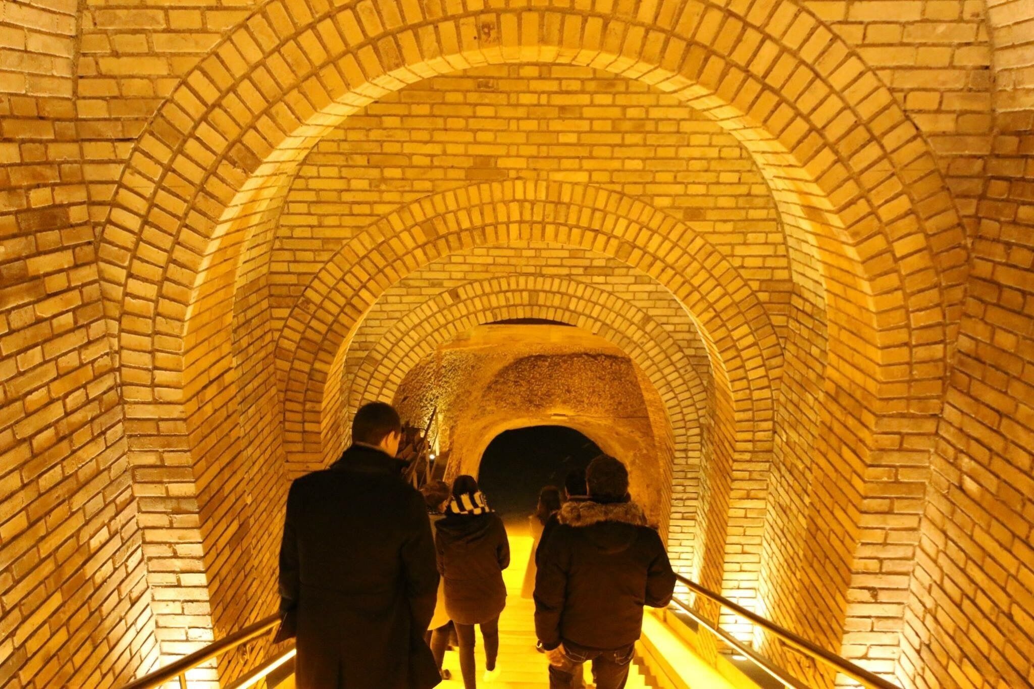 Ein Tunnel mit Ziegelwänden und einem Metallgeländer.