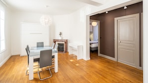 Une chambre moderne avec une table à manger en verre, une cheminée et un lit dans la pièce adjacente.