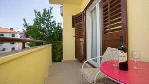 A balcony with a red table, two wine glasses, and a bottle of wine. - Split Center Beautiful Apartment (Split)