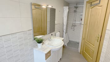 Een bad/douchecombinatie, een haardroger, een bidet, handdoeken
