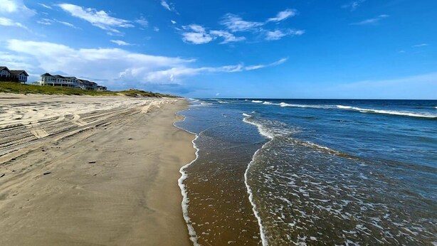 A beach with houses along the shoreline.