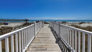 A wooden boardwalk leading to a beach with a clear blue sky. - Against The Wind Side B, Oceanfront Home, Awesome view of Garden City Pier (Garden City Beach)