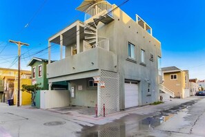 A two-story building with a garage and a small balcony.