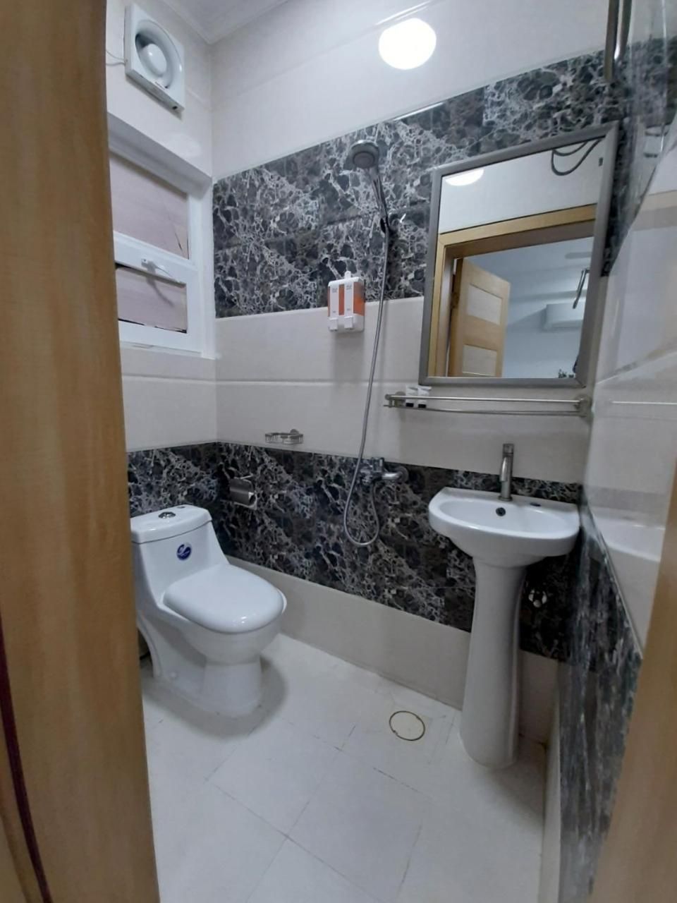 A bathroom with a toilet, sink, and shower.
