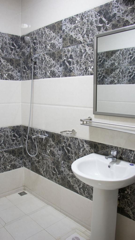 Un baño con ducha, lavabo y espejo.