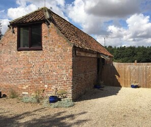 A small brick building with a sloped roof, a window, and a door. - The Lodge Westmoor Farm (Market Rasen)