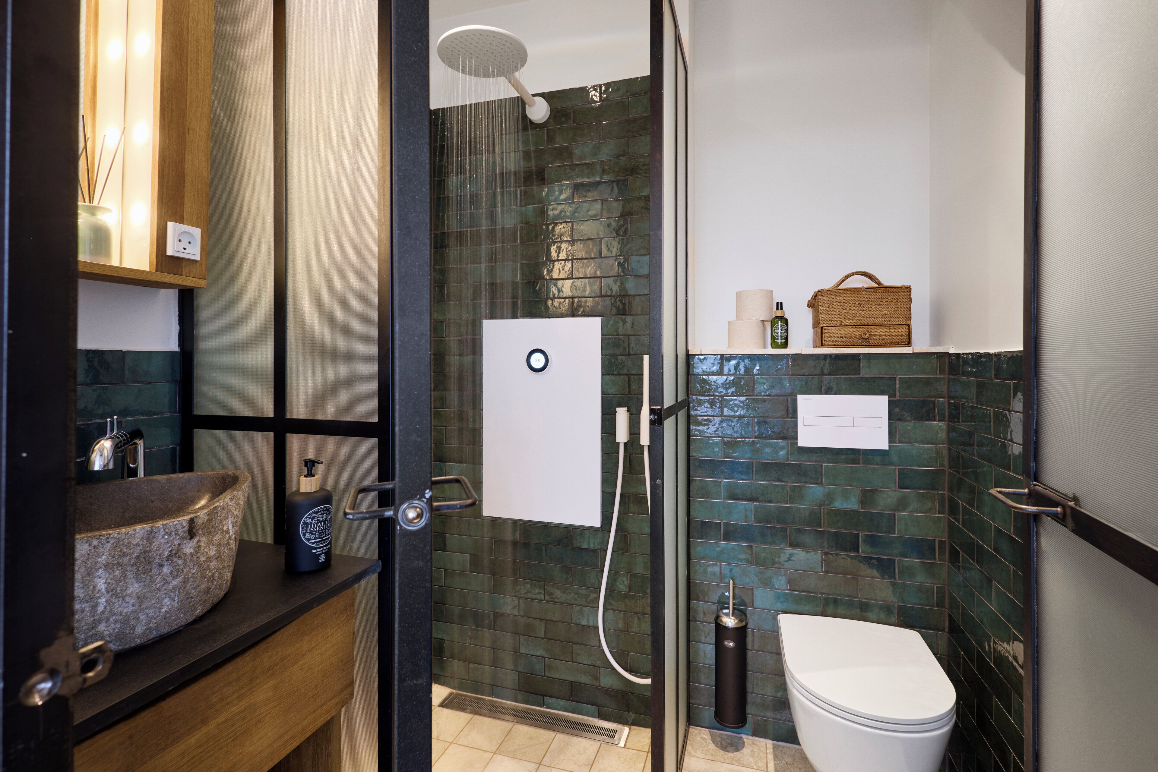 Un baño moderno con lavabo de piedra, ducha e inodoro.
