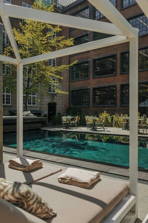 A pool area with lounge chairs and a pergola structure.