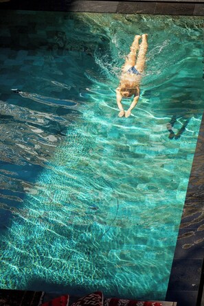 Ein Schwimmbecken mit klarem Wasser und einer Person, die schwimmt.