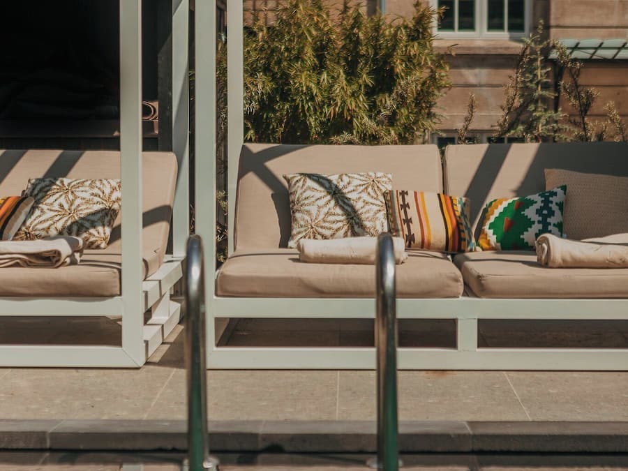 Un área junto a la piscina con sillones reclinables.